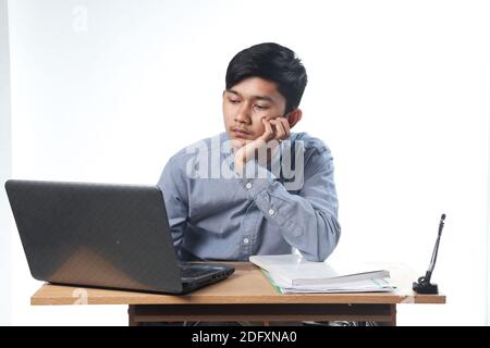 Portrait d'hommes asiatiques travaillant occasionnellement sur des rapports et des livres informatiques. concept animé employé de bureau avec un fond blanc isolé Banque D'Images