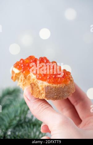 Femelle tenant main de la canape de luxe avec caviar rouge et beurre. Noël, nouvel an cuisine russe hors-d'œuvre Banque D'Images