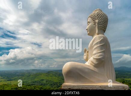 Photo étonnante de la statue de Bouddha de Seigneur en blanc, assis dans la posture de méditation tout en donnant des sermons au sommet de la colline d'où toute la vallée a pu être vue. Banque D'Images