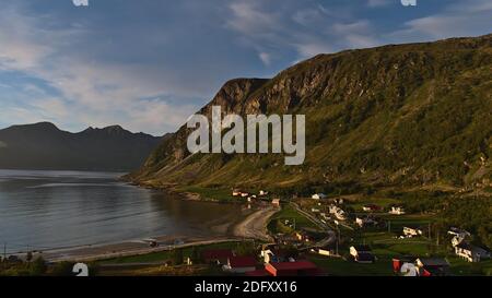 Belle vue panoramique du petit village Grøtfjord situé dans le nord de la Norvège près de Tromsø dans la lumière du soir avec des maisons traditionnelles en bois, plage. Banque D'Images