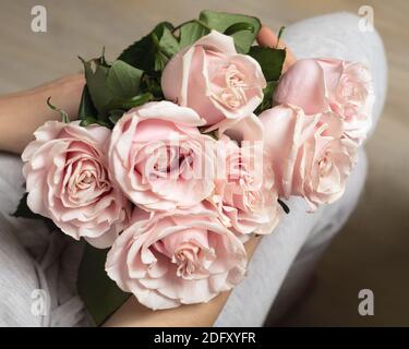 Mains femelles tenant le bouquet de belles roses roses. Banque D'Images