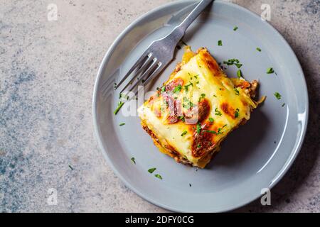 Casserole traditionnelle grecque de pommes de terre et de viande avec fromage - moussaka, fond sombre. Concept de cuisine grecque. Banque D'Images