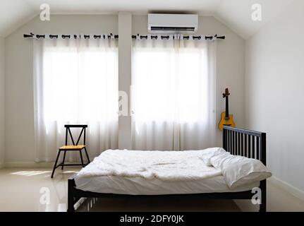 Chambre aux couleurs douces et claires. Grand lit double confortable dans une élégante chambre classique Banque D'Images