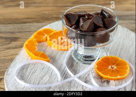 bonbons en gelée d'orange recouverts de chocolat noir savoureux. Bonbons savoureux sur bois blanc. Banque D'Images