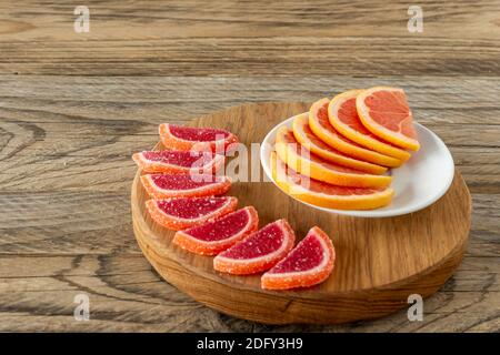 tranches de gelée d'agrumes dans le sucre. tranches de marmelade d'oranges et de pamplemousses sur planche à découper. Banque D'Images