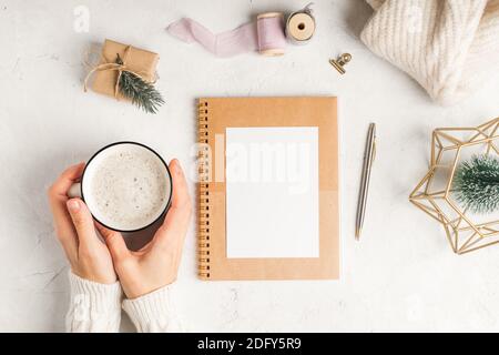 Planificateur vierge de bureau. Fond de table de travail blanc plat avec tasse de café et décoration de Noël. Boules de vue de dessus, sapin, trombones Banque D'Images