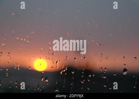 Coucher de soleil à travers le verre. Temps nuageux, paysage flou Banque D'Images