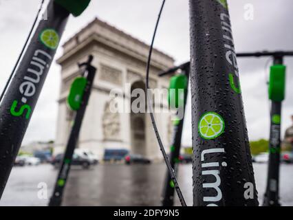 Scooters électriques Lime-S garés au coin de l'avenue Carnot, circulation devant l'Arc de Triomphe à Paris Banque D'Images