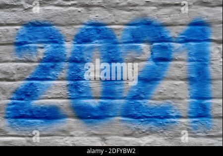 Nouveau texte de l'année 2021 fabriqué avec de la peinture en aérosol bleue sur un mur blanc. Banque D'Images
