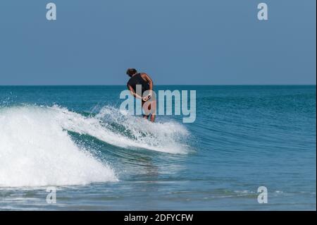 VARKALA, INDE - 14 mars 2020: Un Indien Homme surfant dans les vagues avec style Banque D'Images
