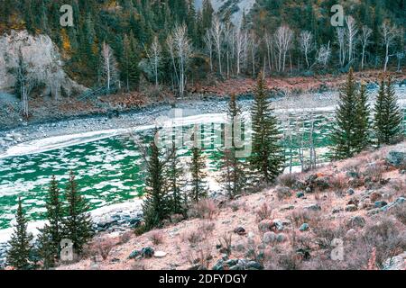Petite rivière menant au lac en début de soirée d'hiver. Dérive de glace dans une rivière de montagne. Banque D'Images
