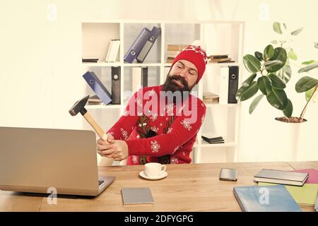 Le stress des fêtes. Homme très occupé a frappé un ordinateur portable avec un marteau. Obtenu le stress au travail. Le travail stressant. Soulagement du stress de Noël. Profitez des fêtes sans stress. Banque D'Images