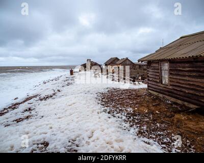 Paysage marin spectaculaire avec une mer blanche qui fait rage et une cabane de pêche sur le rivage. Baie de Kandalaksha. Umba. Russie. Banque D'Images