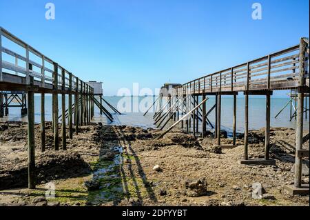 Cabanes de pêcheurs en Bretagne, France. Ces cabanes, construites sur pilotis à cause de la marée, sont utilisées pour pêcher la plie à l'aide de filets suspendus à un mât. Banque D'Images