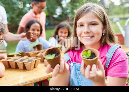 Fille avec des plantules apprend sur les plantes et la biologie dans le camp de vacances écologique Banque D'Images