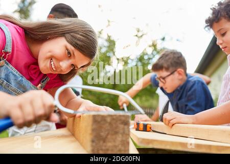 Les enfants travaillent et font de l'artisanat avec du bois dans les artisans atelier au camp de vacances Banque D'Images