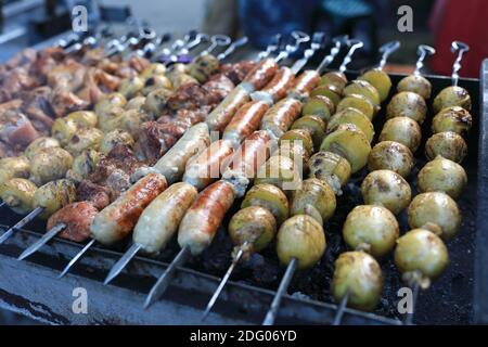 Cuisson de divers kebabs sur des brochettes au pique-nique Banque D'Images