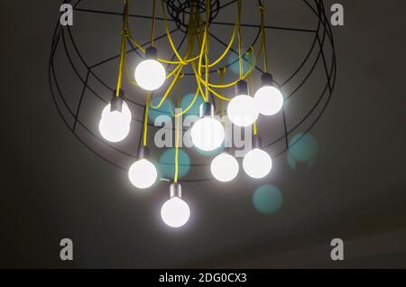 Composition abstraite avec un lustre moderne lumineux dans le style high-tech sous le plafond. Lustre avec feux d'aile et fils jaunes. Sélectif f Banque D'Images