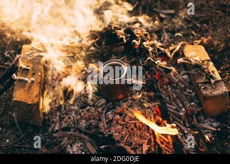 Café en cours de fabrication sur un feu de camp, à l'extérieur dans les bois. Banque D'Images