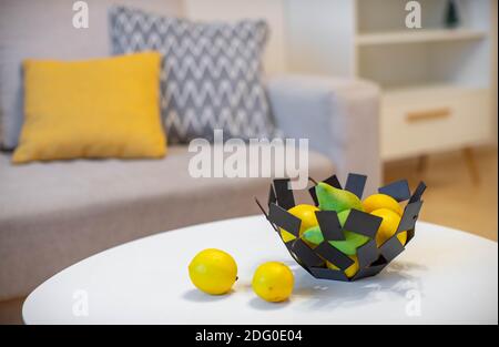 Gros plan d'un bol décoratif avec fruits sur une table blanche. Citrons et poires. Intérieur moderne. Banque D'Images