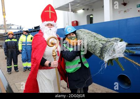 Rostock, Allemagne. 07ème décembre 2020. Alors que Saint Nicholas, Stefanie Zernikow, couturière de la diaconesse, apporte un arbre de Noël à bord du cargo Miramar dans le port maritime, Ulrike Seperant (r) l'aide. Pour l'action traditionnelle de la Mission des marins 'Hollfast', le magasin spécialisé de jardin Rostock 'Grönfingers' a donné les firs Nordmann. Credit: Bernd Wüstneck/dpa-Zentralbild/dpa/Alay Live News Banque D'Images