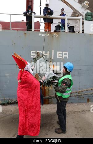 Rostock, Allemagne. 07ème décembre 2020. Comme Saint Nicholas, Stefanie Zernikow, la diaconesse mateleuse, avec Heiko Rademacher, apporte un arbre de Noël à bord du cargo 'Nordic Falcon' dans le port maritime. Pour l'action traditionnelle de la mission des marins 'Hollfast', le magasin spécialisé de jardin Rostock 'Grönfingers' a fait don des sapins Nordmann. Credit: Bernd Wüstneck/dpa-Zentralbild/dpa/Alay Live News Banque D'Images