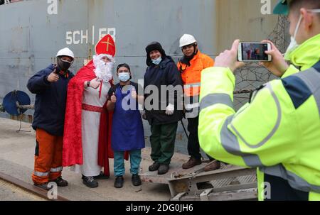 Rostock, Allemagne. 07ème décembre 2020. Comme Saint Nicholas, Stefanie Zernikow, la diaconesse mateleuse, est heureuse de prendre une photo souvenir après avoir apporté un arbre de Noël à bord du cargo 'Nordic Falcon' dans le port maritime. Pour l'action traditionnelle de la Mission des Seamen 'Hollfast', le centre de jardin Rostock 'Grönfingers' a fait don des sapins Nordmann. Credit: Bernd Wüstneck/dpa-Zentralbild/dpa/Alay Live News Banque D'Images