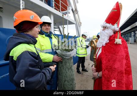 Rostock, Allemagne. 07ème décembre 2020. Mika Pertsjonok (l-r) d'Estonie et Igor Derkach de Russie du cargo 'Miramar' parlent à Stefanie Zernikow, couturière deaconess, qui a amené un arbre de Noël à bord du cargo sous le nom de Saint Nicholas. Pour l'action traditionnelle de la mission des marins 'Hollfast', le magasin spécialisé de jardin Rostock 'Grönfingers' a donné les firs Nordmann. Credit: Bernd Wüstneck/dpa-Zentralbild/dpa/Alay Live News Banque D'Images