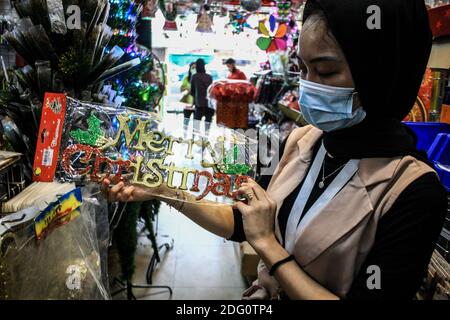 Medan, Sumatera du Nord, Indonésie. 7 décembre 2020. Un ouvrier a vu la compilation d'un ornement Joyeux de Noël à être vendu au marché de la Décoration de Noël à Medan, au nord de Sumatra. Crédit : Kartik Byma/SOPA Images/ZUMA Wire/Alay Live News Banque D'Images