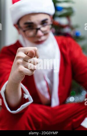 le père noël montre la photo. Attention à la main. Noël gâté. Annulation des vacances du nouvel an. Noël en quarantaine en raison du coronavirus Banque D'Images