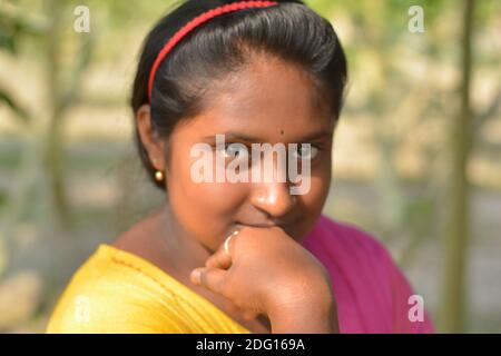 Gros plan d'une adolescente bengali indienne portant un salwar de couleur jaune et une dhupatta rose avec bindi sur le front, concentration sélective Banque D'Images