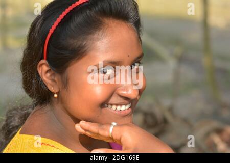 Gros plan d'une adolescente bengali indienne portant un salwar de couleur jaune et une dhupatta rose avec bindi sur le front, concentration sélective Banque D'Images