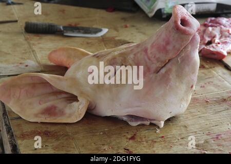 Tête de porc sur un stand de viande sur un marché en Asie. Banque D'Images