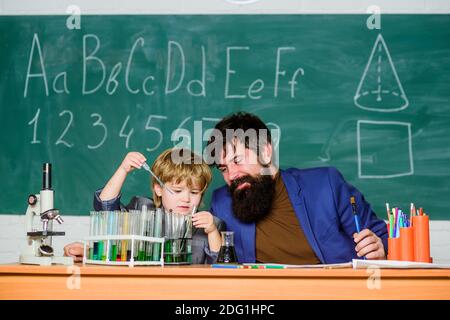 Connaissances de base en chimie. Étudier la chimie et la biologie. Jouez avec des liquides. Exemple personnel inspirant. Connaissances scolaires. Professeur et laboratoire de chimie de garçon. Journée de la connaissance vacances de septembre. Banque D'Images