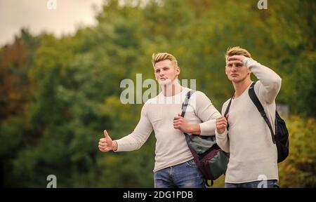 Des amis qui voyagent avec des hitchhikers. Geste de randonnée. Commencez une grande aventure dans votre vie avec la randonnée pédestre. Compagnie amis voyageurs qui déchire à la route nature fond. Voyageurs en route. Banque D'Images