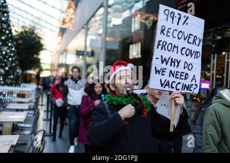 Manifestation anti-verrouillage à Stratford, Londres, 5 décembre 2020. Un manifestant avec écriteau traverse le centre commercial Westfield. Banque D'Images