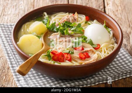 Soupe péruvienne de poulet Caldo de Gallina dans la plaque sur la table. Horizontale Banque D'Images