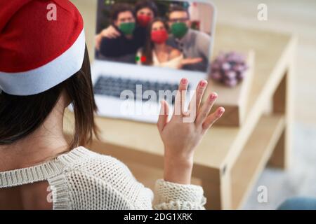Femme adulte célébrant Noël à la maison et effectuant un appel vidéo avec des amis Banque D'Images