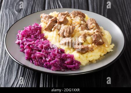 Cuisine hollandaise ragoût de boeuf et d'oignon servi avec une purée de pommes de terre et de chou rouge dans une assiette sur la table. Horizontale Banque D'Images