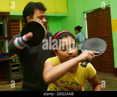 Kajol Dey, un joueur et entraîneur de tennis de table handicapé de 49 ans, est vu coacher une jeune fille dans son camp d'entraînement à l'occasion de la Journée internationale des personnes handicapées (IDPD). Agartala, Tripura, Inde. Banque D'Images