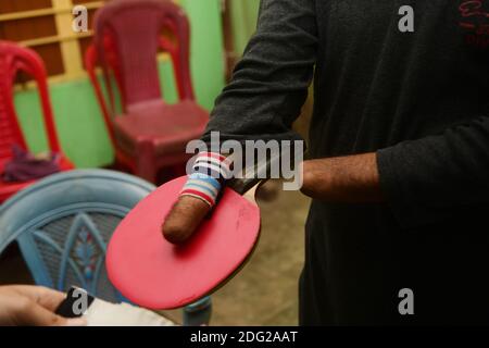 Kajol Dey, un joueur et entraîneur de tennis de table handicapés de 49 ans, se prépare à coacher une jeune fille dans son camp d'entraînement à l'occasion de la Journée internationale des personnes handicapées (IDPD). Agartala, Tripura, Inde. Banque D'Images