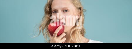 Bannière longue largeur avec portrait de la jeune femme qui bite la pomme. Visage frais, beauté naturelle, Banque D'Images