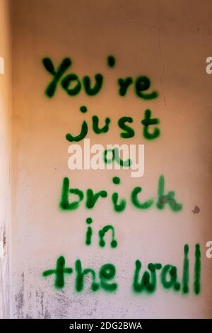 Mur de maison démoli avec l'inscription effrayante « You're just a brick in the Wall » dans le village fantôme d'Al Madame, Émirats arabes Unis. Banque D'Images