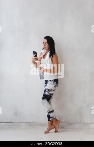 Femme sportive faisant le selfie après l'entraînement sur le fond de mur blanc. Banque D'Images