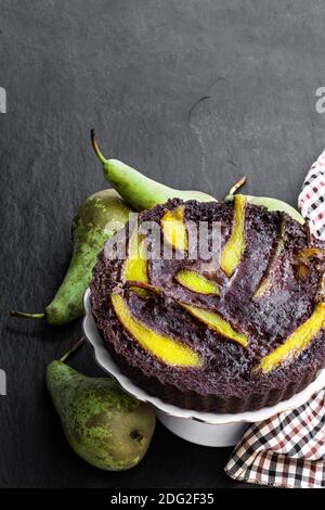 Gâteau au chocolat brownie avec poire pochée sur fond de pierre noire Banque D'Images