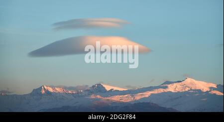 Grands nuages lenticulaires blancs au-dessus de la Sierra Nevada (Espagne) au coucher du soleil Banque D'Images