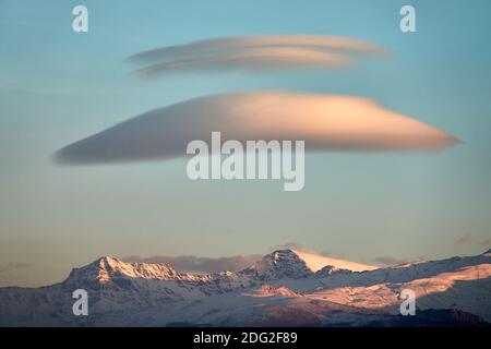 Grands nuages lenticulaires blancs au-dessus de la Sierra Nevada (Espagne) au coucher du soleil Banque D'Images