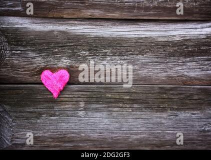 Petit coeur décoratif sur fond ancien en bois. Banque D'Images