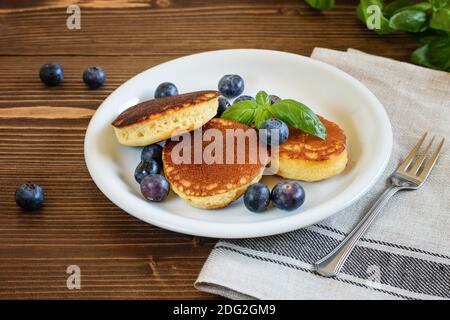 Crêpes japonaises moelleuses savoureuses avec myrtilles sur la plaque blanche, gros plan. Concept de saine alimentation. Banque D'Images