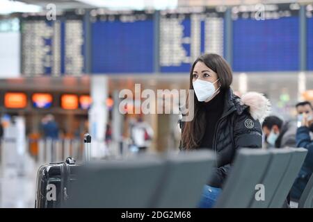 Voyages à thème en période de pandémie de corona. Jeune femme avec masque, masque à l'aéroport de Munich le 6 décembre 2020. Assis dans le terminal, hall des départs, en attente du départ. MODÈLE DISPONIBLE ! | utilisation dans le monde entier Banque D'Images